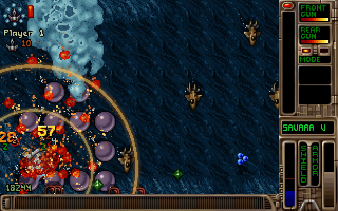 Tyrian gameplay over Savara V: the player's ship among Modern explosions and damage numbers